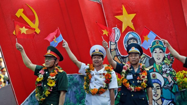 Vietnamese military personnel wave flags during a parade celebrating the 40th anniversary of the end of the Vietnam War which is also remembered as the "Fall of Saigon," in Ho Chi Minh City, Vietnam.