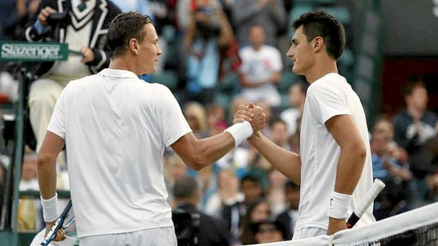 Tomas Berdych of the Czech Republic, left, shakes hands with Bernard Tomic of Australia after defeating him during at the All England Lawn Tennis Championships in Wimbledon.