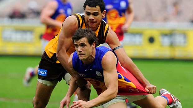 Next generation: Jed Adcock is hassled by Hawthorn?s Cyril Rioli.