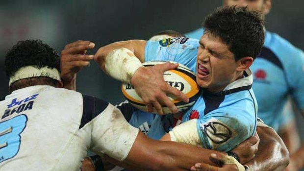 Crunch time . . . Waratahs back Tom Carter, who came on as a late replacement, gets acquainted with the Blues defence at the SFS on Saturday.
