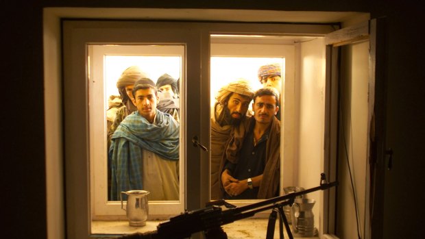 Afghans look through the window into the bedroom of Taliban leader Mullah Omar as they go through his compound on the outskirts of the Afghan city of Kandahar in 2001.