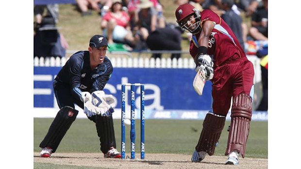 Kirk Edwards lofts a delivery to the boundary as New Zealand wicketkeeper Luke Ronchi looks on.