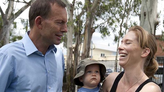 Federal Opposition Leader Tony abbott (left) speaks with Caroline O'connor and her 10-month-old baby Tom in the Walton Bridge Reserve in the seat of Ashgrove on Feb 18, 2012.