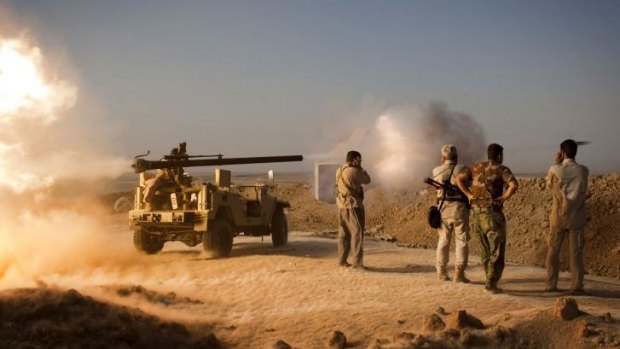 Kurdish fighters fire towards Islamic State positions during clashes south of Kirkuk, Iraq.