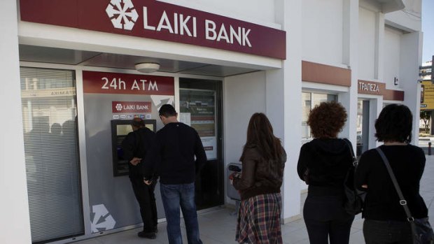Rush for cash: Customers queue at a Laiki Bank ATM.