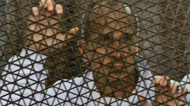 On trial: Peter Greste inside the defendants' cage in Cairo courtroom.