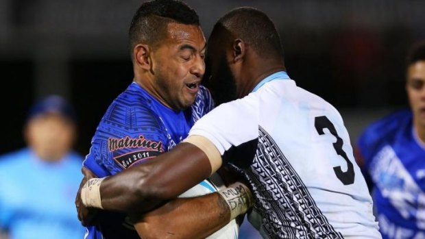 No rush: Samoan centre Krisnan Inu is tackled by Fijian counterpart Semi Radradra.