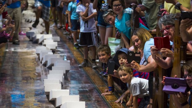 Melbournians gathered to watch a 2-kilometre domino train wind its way through the city, including the aisle of St Paul's Cathedral. 