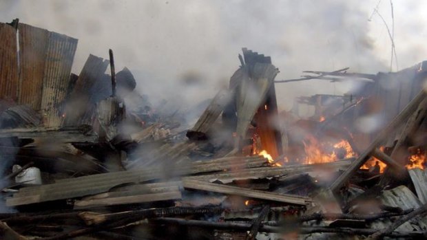 Fire smoulders at the scene of a petrol pipeline accident at a slum near the industrial area of Nairobi.