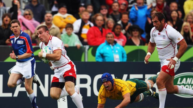 Vladimir Ostroushko brakes past Nathan Sharpe to score for Russia against Australia. It was one of eight tries they scored in the tournament.