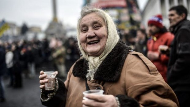 An old woman smiles while visiting Kiev's Independence Square.