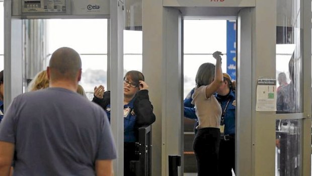 Passengers are scanned at a security checkpoint at Logan Airport in Boston using a millimetre wave body scanner, which produces a cartoon-like outline rather than naked images of passengers.