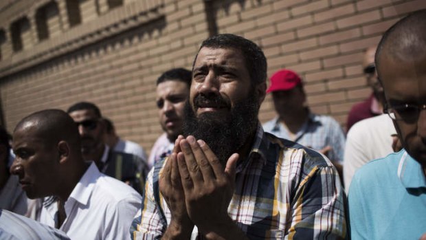 A friend of Ammar Badie, the son of Muslim Brotherhood's spiritual leader Mohammed Badie, who was killed Friday by Egyptian security forces during clashes in Ramses Square, cries while attending his burial in Cairo's Katameya district, Egypt.