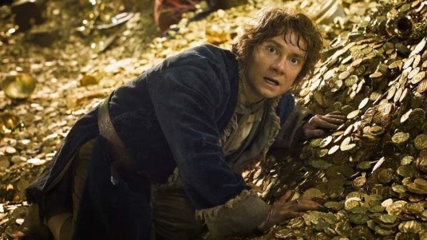 Show me the money: Bilbo rummages among the gold in Smaug's lair.