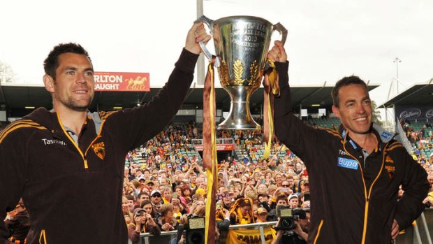 Plenty to celebrate: Hawks captain Luke Hodge (left) and Clarkson present the cup to the Tasmanian faithful on Monday.