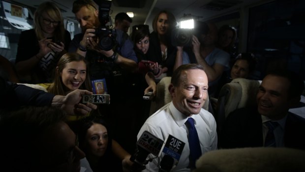 Potential winners are grinners: Tony Abbott joins a media bus group during his campaign visit to Brisbane, as an opinion poll brought good news for the Coalition.