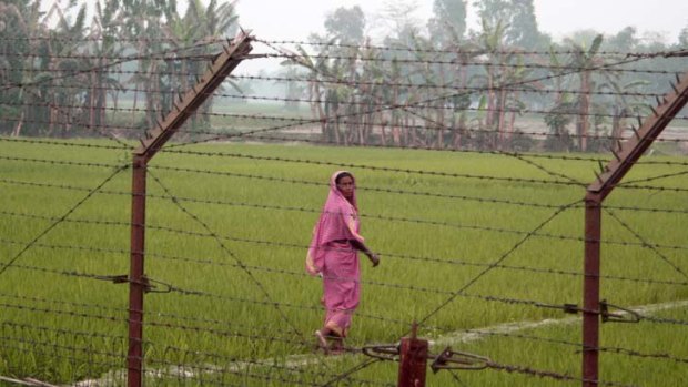 Fenced in ... a woman looks back through the controversial India-Bangladesh border fence.