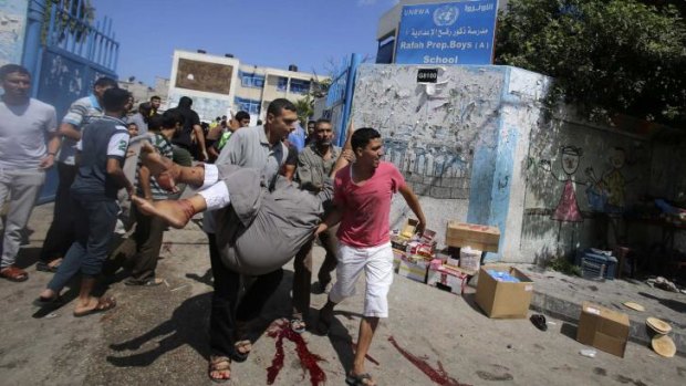 Palestinians carry a wounded man after an Israeli air strike at a UN school in Rafah on Sunday.