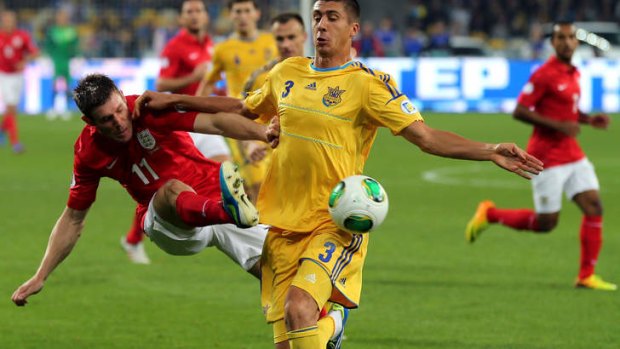 James Milner of England and Yevhen Khacheridi of Ukraine battle for the ball.