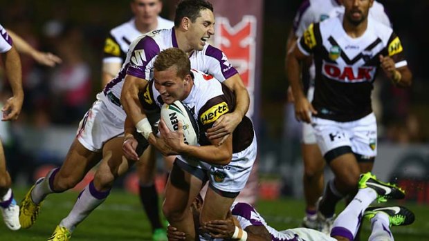 Wrapped up: Storm's Billy Slater lays a tackle on Penrith's Matt Moylan during Monday night's match.