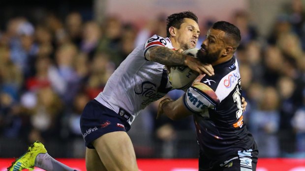Badly missed: Mitchell Pearce tackles Jayson Bukuya of the Sharks.