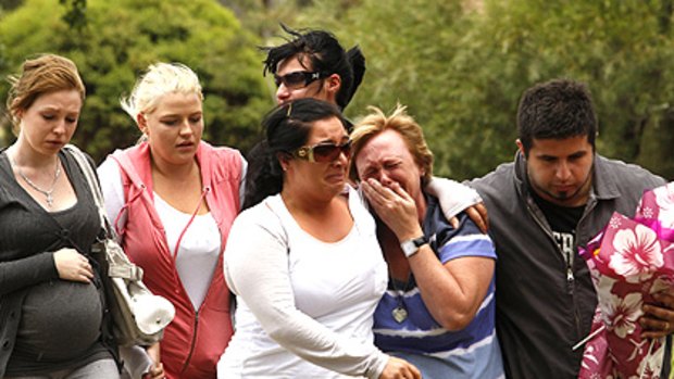 Distraught friends and family gather at the scene of yesterday’s single-vehicle crash in Mill Park, which left five teenagers dead and injured a girl.