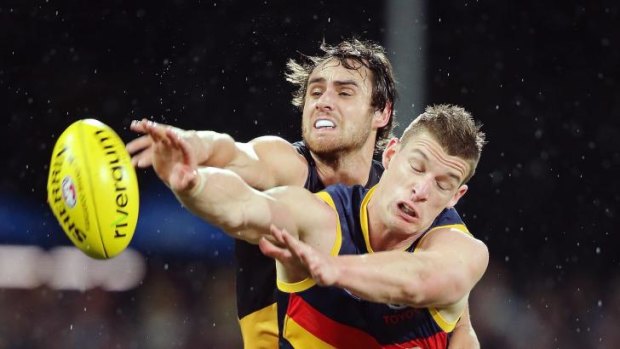 Ben Griffiths of the Tigers competes with Josh Jenkins of the Crows at the Adelaide Oval on Saturday night. 