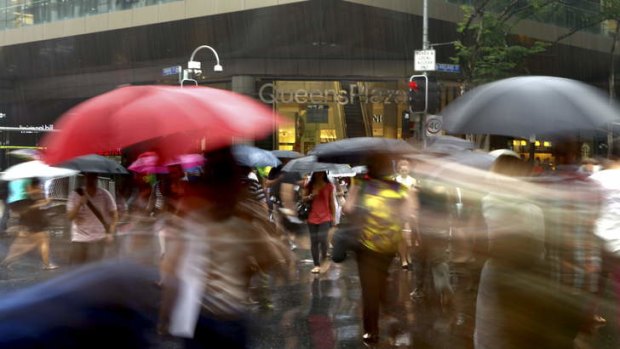 People dodge the rain on Friday afternoon in the Brisbane CBD ahead of a forecasted wet weekend.