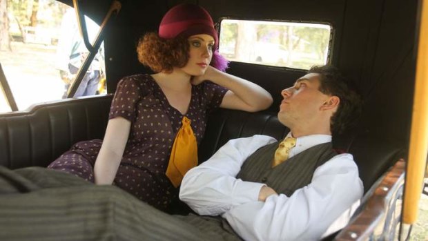 Gracie Gilbert and Jared Daperis chatting in the back seat of the vintage Minerva car.