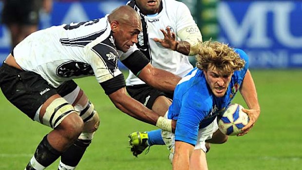 Italy's Mirco Bergamasco (R) tries to escape from  Fiji's Semisi Saukawa.