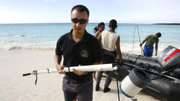 A French investigator carries equipment at Galawa beach before a search mission for the missing Yemenia A310-300 plane, in Mitsamiouli, 30km north of Comores islands' capital Moronoi.
