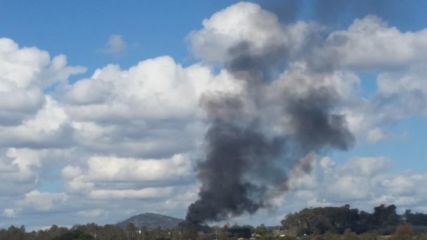 Black smoke billows over the suburb of Wright after a shed caught fire.
