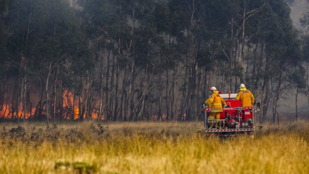 Crews work to contain a fire near Bungendore that has burnt through more than 1100 hectares of land off the Kings Highway. The highway remained closed on Wednesday night.