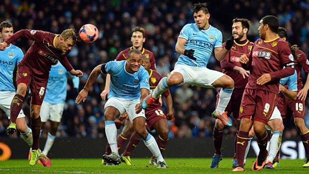 Manchester City's Argentine striker Sergio Aguero (centre) heads the ball towards goal during the match against Watford on Saturday.