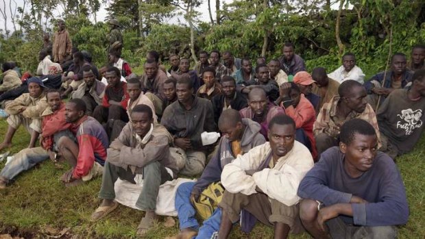 Suspected M23 rebel fighters sit in a group after surrendering to the Congolese army in Chanzo village in the Rutshuru territory near the eastern town of Goma.