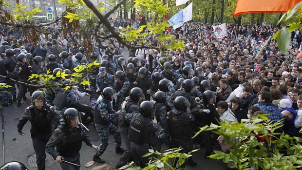 Russian riot police scuffle with protesters.