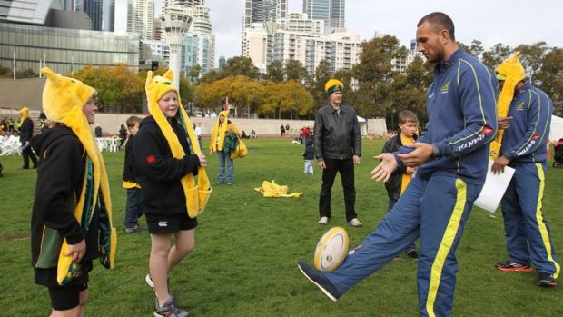 Personal touch ... Quade Cooper enjoys a kick-around with young supporters during a Wallabies fan day at Tumbalong Park, Darling Harbour yesterday.