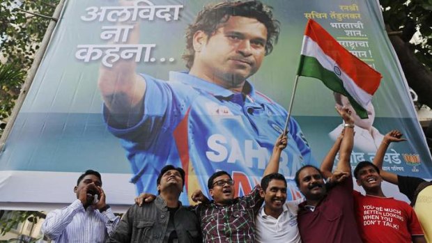 National hero: Cricket fans in front of a billboard of cricketer Sachin Tendulkar outside a stadium in Mumbai.