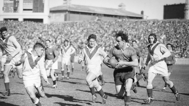 Old school: Clive Churchill weaving his magic for the Rabbitohs against the Dragons at the SCG in 1953.
