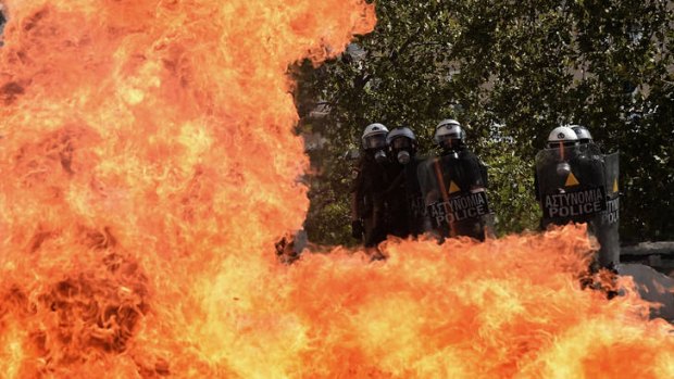 A fireboomb explodes in front of riot police during clashes with demonstrators.
