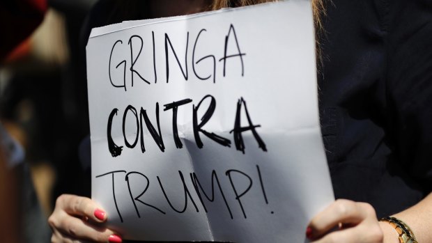 Kristin Smith, an American living in Mexico City, holds a sign with a message that reads in Spanish; "Gringa against Trump." 