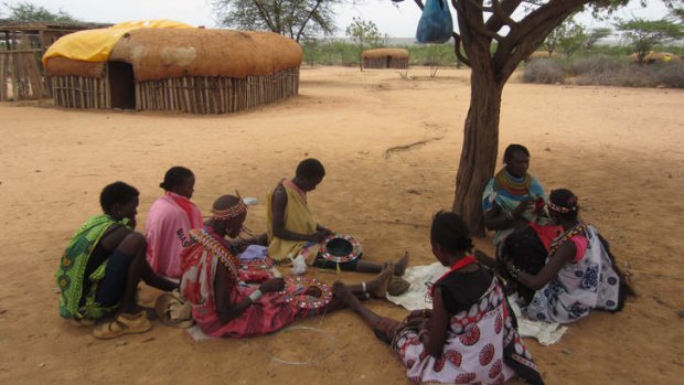 Sheltered: Umoja women do beadwork under a tree.