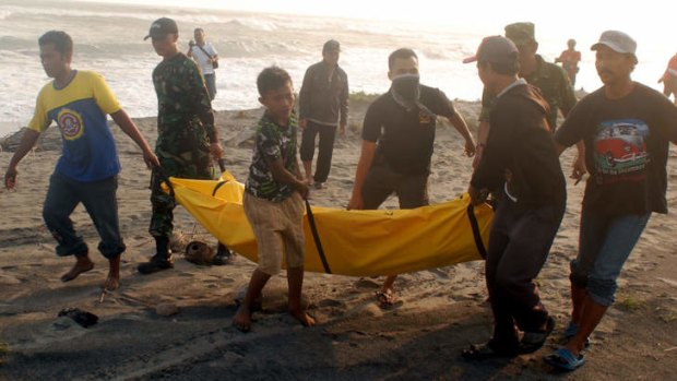 Rescuers with a victim of the boat sinking off Java.