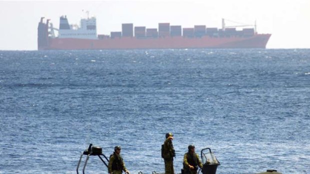 Australian special force soldiers ride their inflatable boat past the captured Norwegian freighter, Tampa. After Tampa, the navy was ordered to force back every boat.