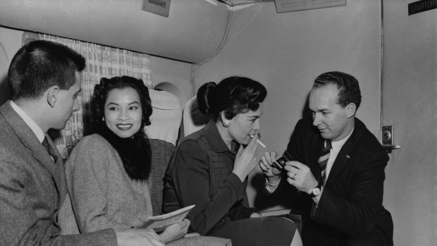 Passengers enjoy a relaxing smoke on a Transocean Air lines Boeing 377 Stratocruiser in the mid 1950's. Transocean Air lines flew between 1946 and 1962 and was a pioneer discount airline.