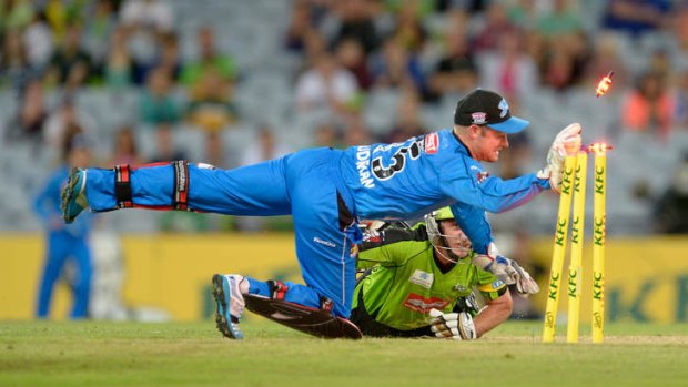 Mike Hussey of the Thunder dives into his crease to avoid being run out by Tim Ludeman of the Strikers.