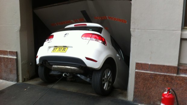 Going down: The woman's rental car became lodged in an inner city apartment lift well.