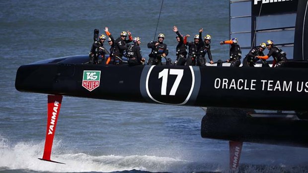 Members of Oracle Team USA wave to spectators after winning Race 17 of the 34th America's Cup.