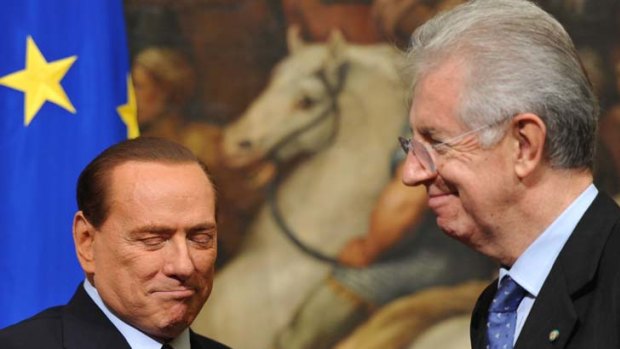 Reluctant handover ... Silvio Berlusconi, shakes hands with his successor, Mario Monti.