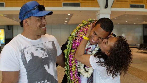 Reunited: William Hopoate (centre) catches up with his parents, John and Brenda, after his two-year Mormon mission.